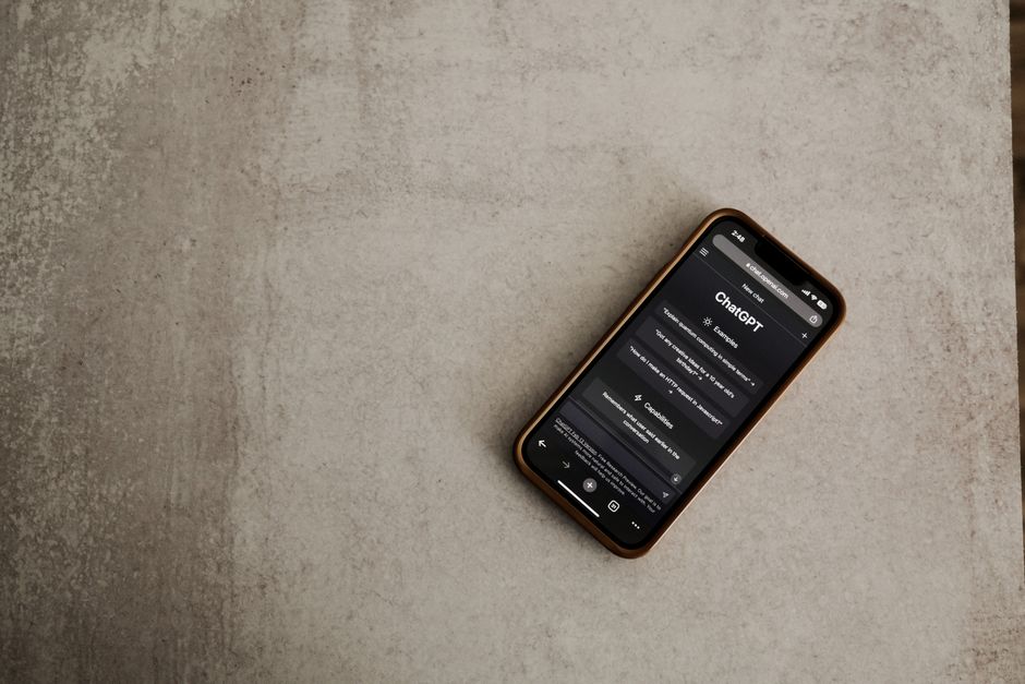 Close-up de um smartphone com o aplicativo ChatGPT aberto, destacando a tecnologia de IA em uma superfície texturizada.